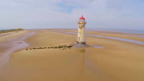 una magnífica toma aérea del faro de point of ayr en gales con una cerca desgastada en primer plano