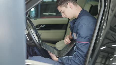 mechanic performing car diagnostics with laptop