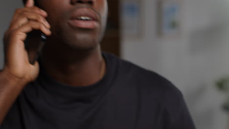 unhappy and depressed young man getting up from sofa at home talking on mobile phone