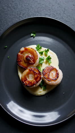 gourmet seared scallops with mashed potatoes and fresh parsley garnish