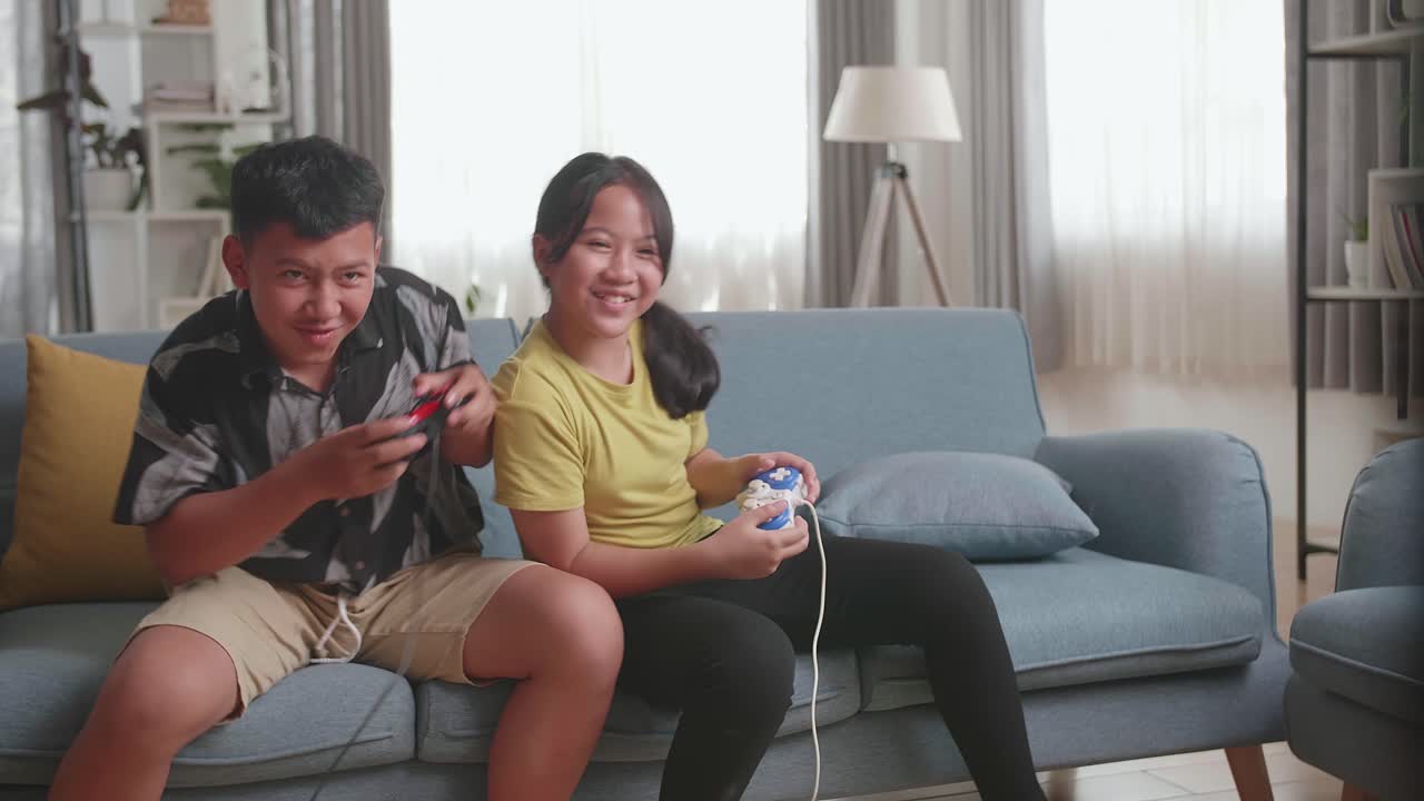 Funny Asian Children With Joystick Game Playing Video Games On Tv At Home