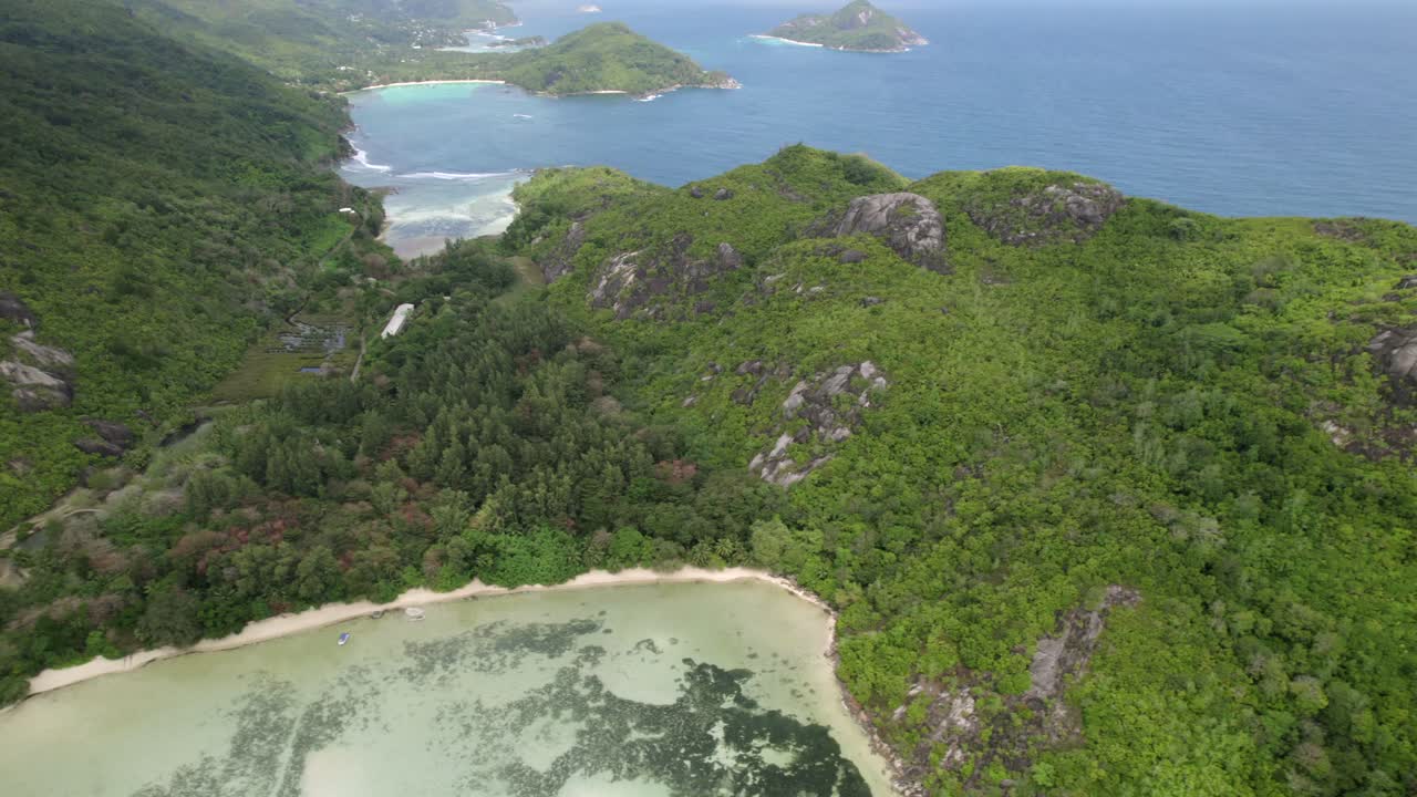 High drone footage from cap ternay beach, view of port launay beach, lush forest and beautiful beaches, Mahe, Seychelles 30fps