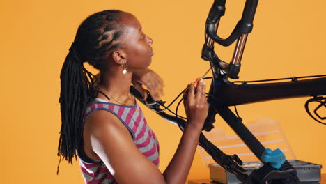 engineer uses screwdriver to unmount bicycle handlebars, studio background