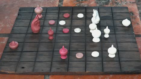 people playing chess on a homemade chess board