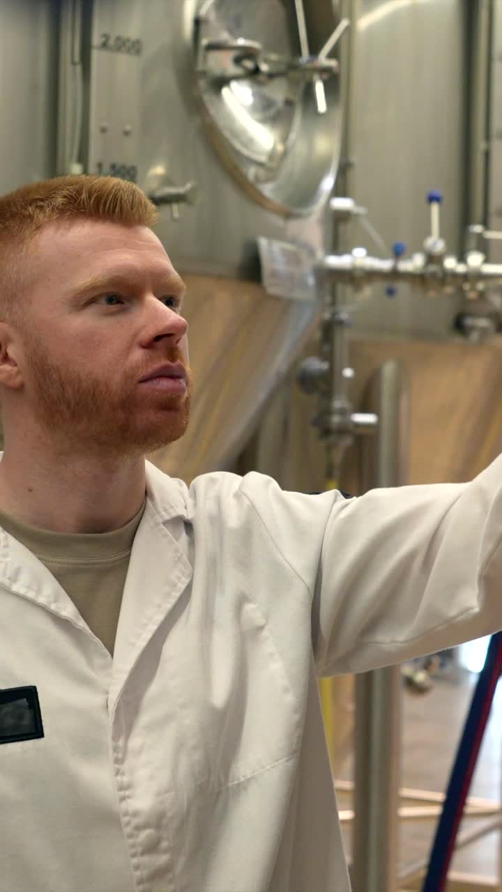 Man holding a glass of beer in a brewery
