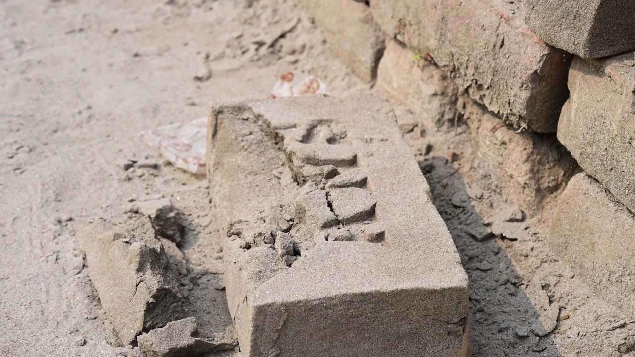 Close-up view of a damaged and cracked clay block discarded on the ground at a factory in Bangladesh. Shows manufacturing waste, raw material textures, and defective production units in Dhaka.