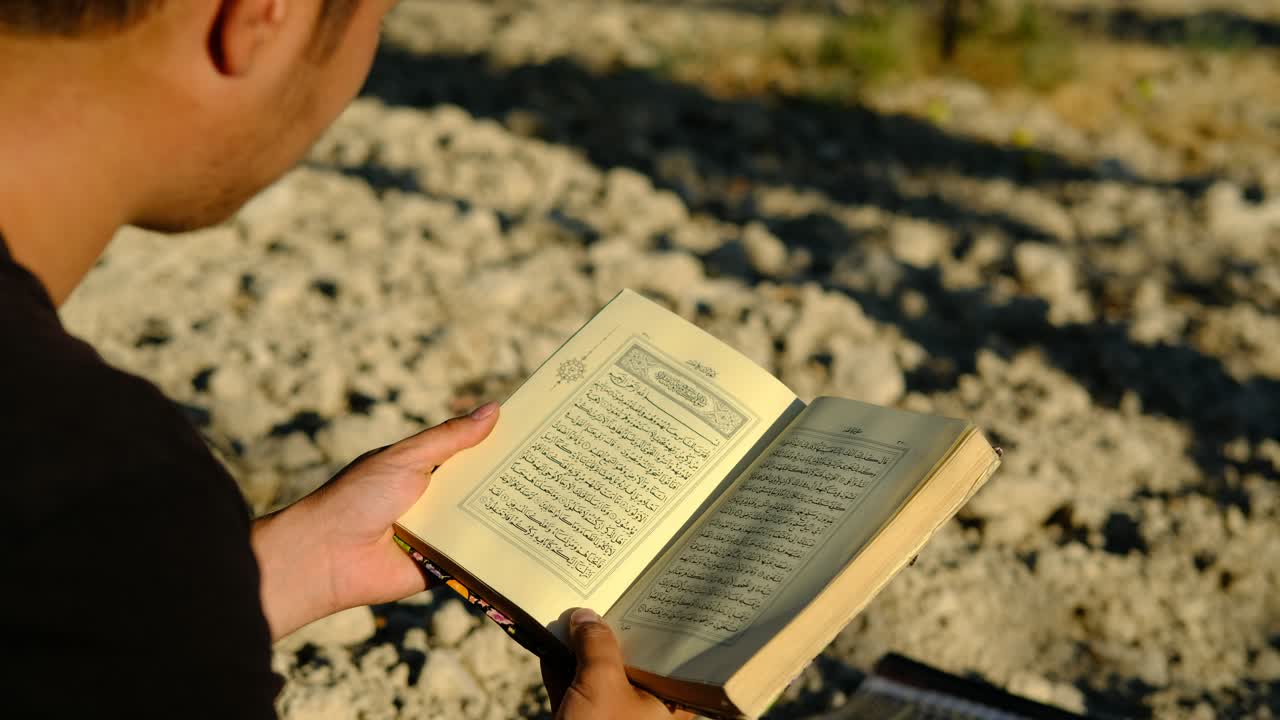 Young man reading quran outdoors