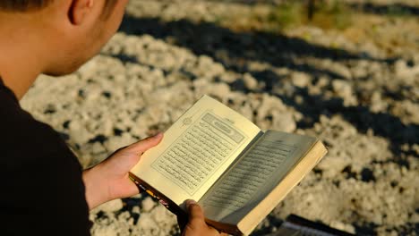 joven leyendo el corán al aire libre