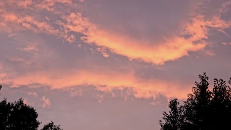 un impresionante cielo al atardecer pintado con tonos de nubes rosas y naranjas, capturando la belleza de la naturaleza al anochecer