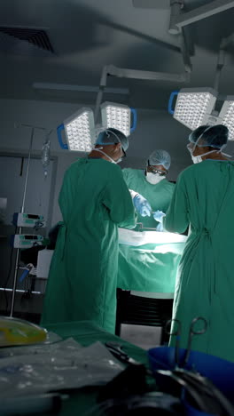vertical video of diverse surgeons with face masks during surgery in slow motion