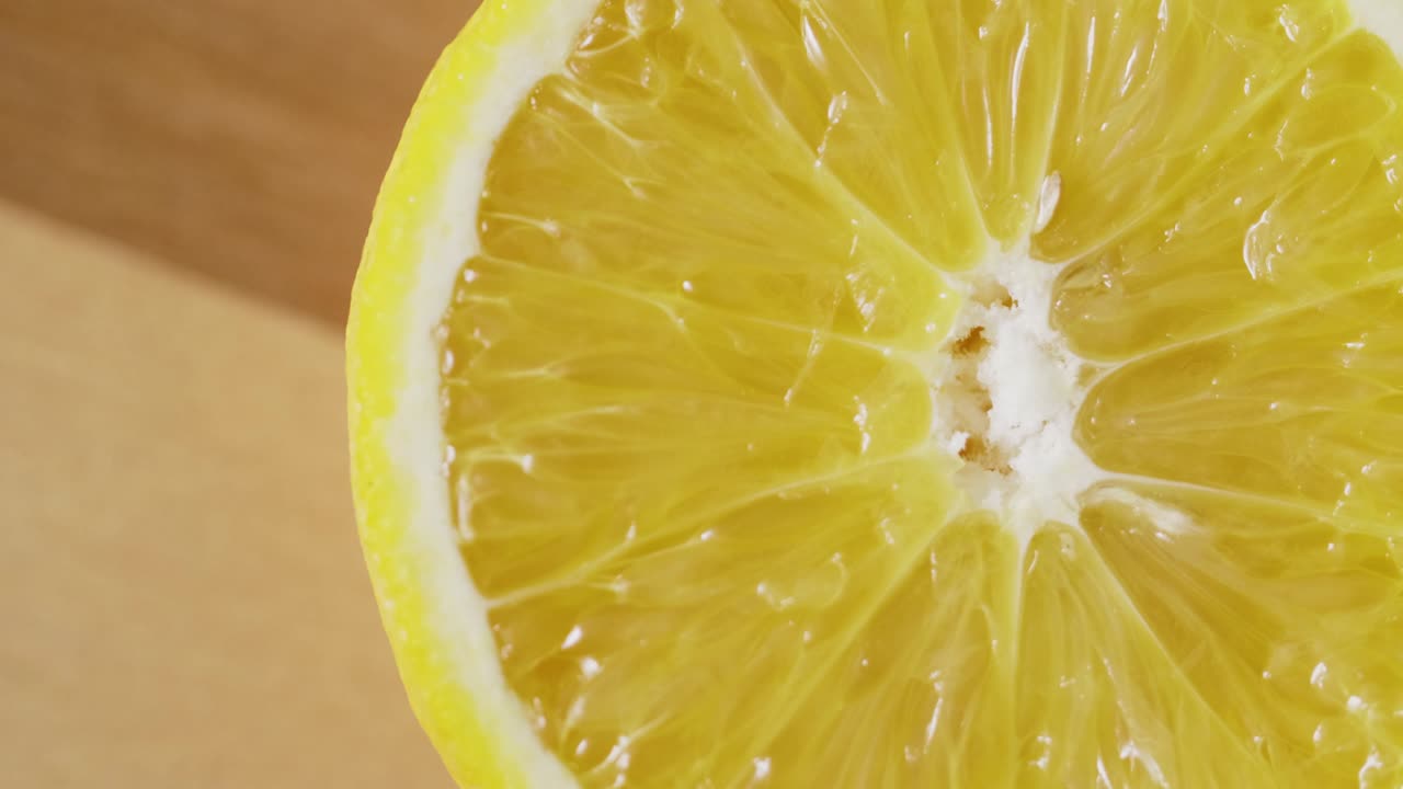 primer plano extremo de una naranja recién cortada girando sobre la mesa