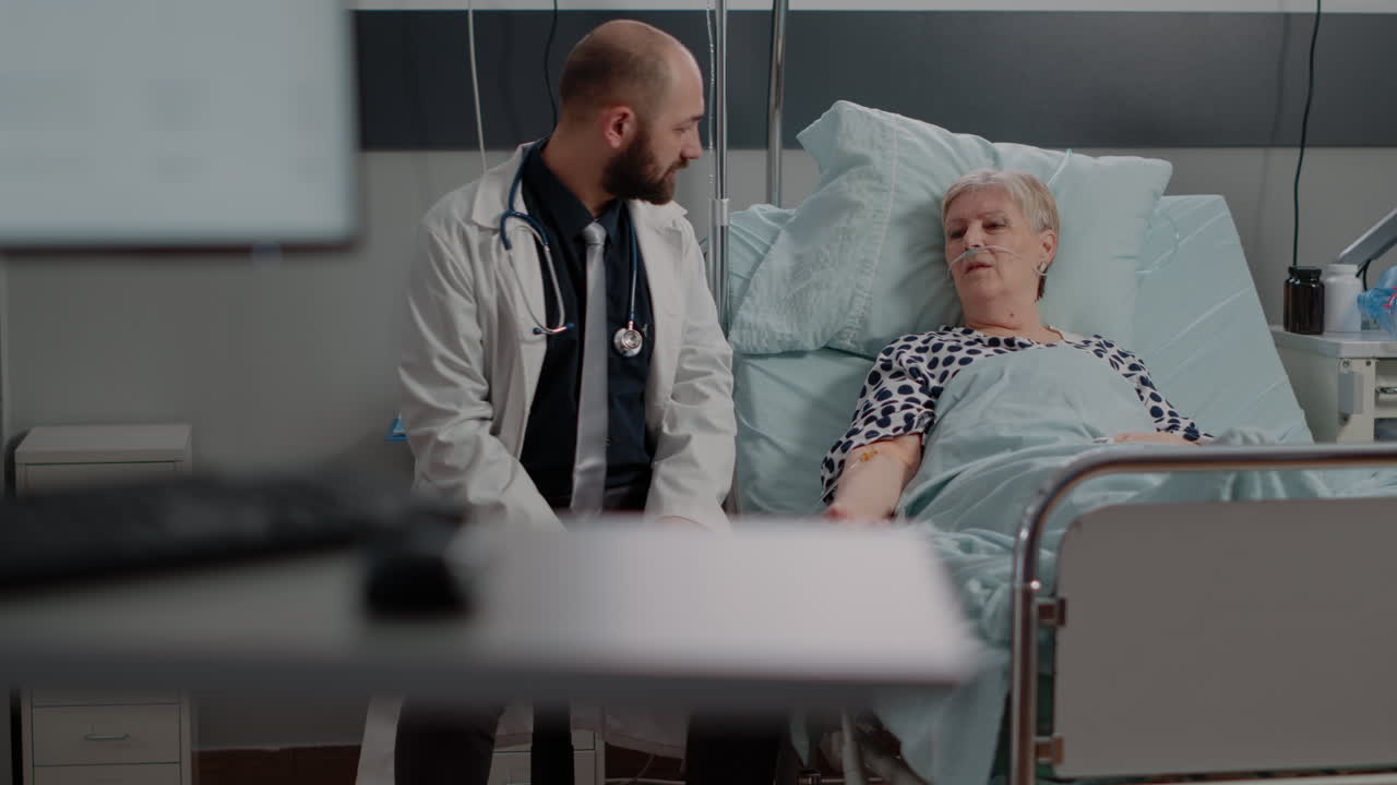 Doctor talking to retired woman with disease in hospital ward