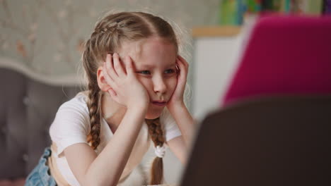 bored little girl with braided hair looks at musical sheets