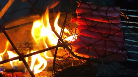 skewered sausages are grilled on a hot grill over traditional fireplace