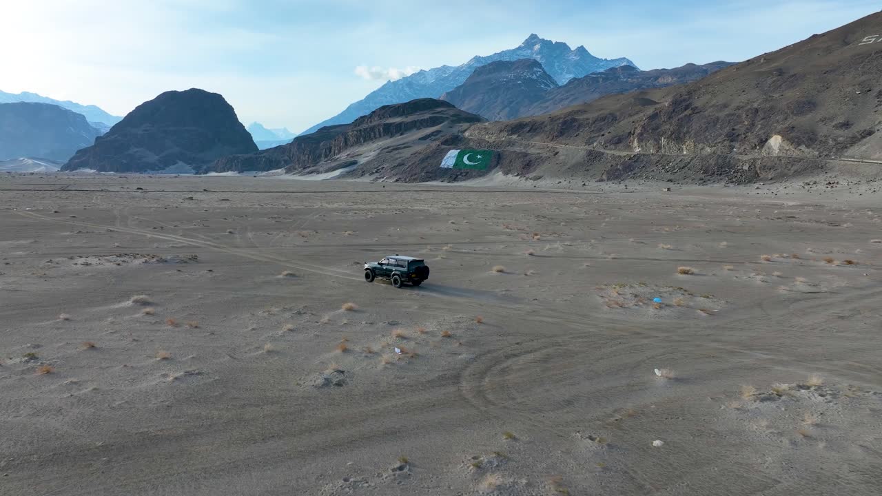 vehículo todoterreno que atraviesa el desierto frío de sarfaranga con una bandera de pakistán en el valle de skardu