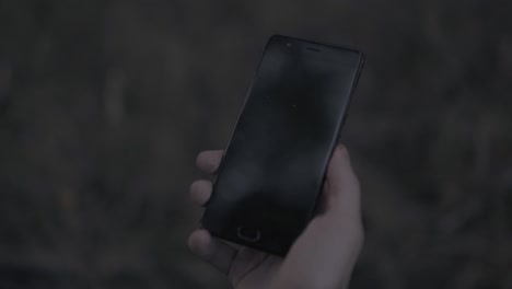close up de un hombre con la mano sosteniendo un teléfono inteligente con pantalla verde. stock. teléfono móvil moderno con tecla de croma en fondo borroso