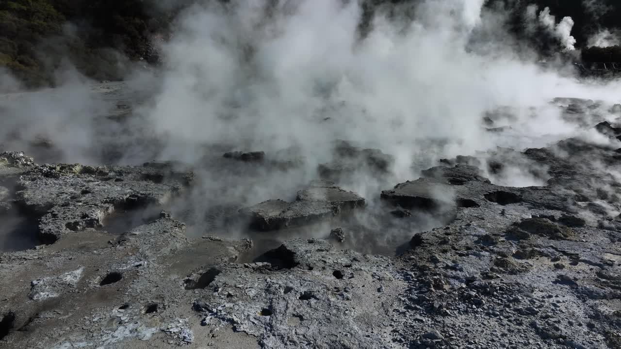 Drone slowly flying over geothermal landscape with bubbling mud and steam. Alien Landscape. Sci-fi. Global Warming