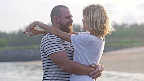 romantic couple standing in ocean and embracing