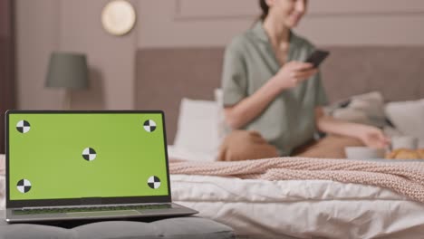 laptop with chromakey in womans bedroom