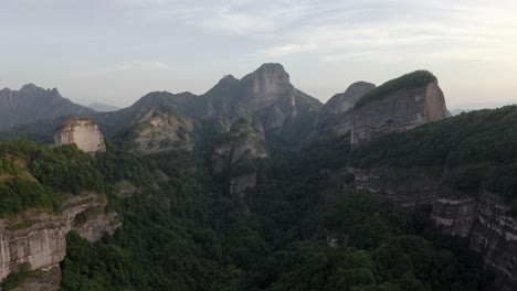 Aerial:-Bajiaozhai-valley-in-mountainous-China-countryside,-sunset-landscape