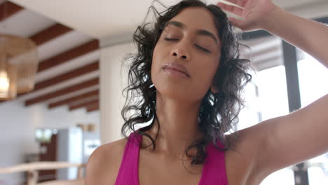 biracial woman doing yoga and stretching at home, slow motion