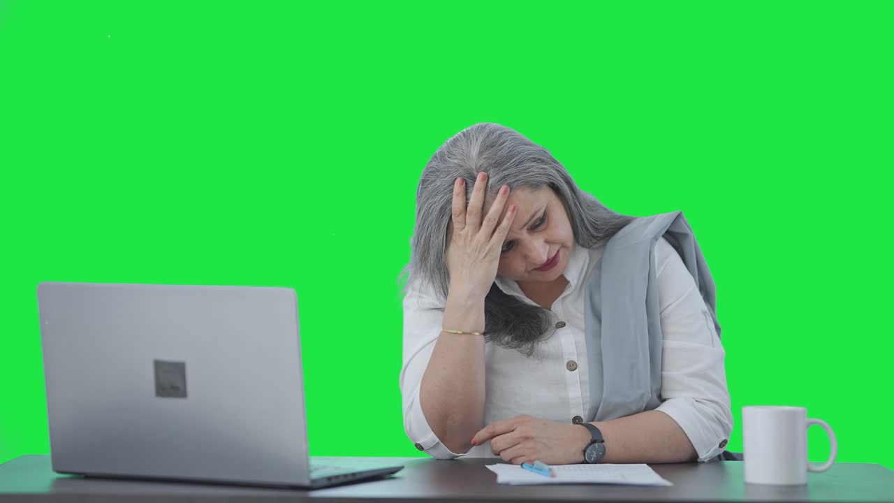 tensa mujer de negocios india senior pensando en algo pantalla verde