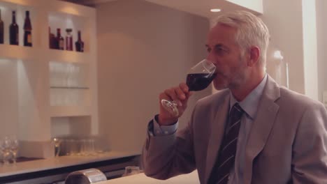 businessman drinking glass of red wine