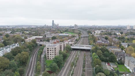 aerial view of the main train line from bristol into london, featuring traffic moving across multiple bridges amid residential and commercial buildings in ealing, london, uk