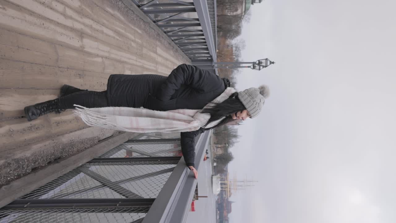 스웨덴 스 ⁇ 홀름 의 구 시가지 에서 관광 을 하고 있는 여자 의 수직적 인 모습