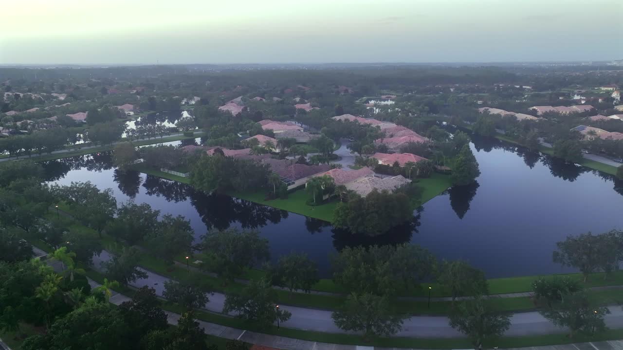 Luxury suburb neighborhood of Florida at foggy day. Aerial establishing shot. Villas with orange tile roof and private rivers. Wide shot. Quiet and exclusive residential area in Orlando