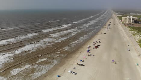 Rising-above-a-broad-view-of-the-ocean---beach,-flying-forward-down-the-length-of-the-tide-line