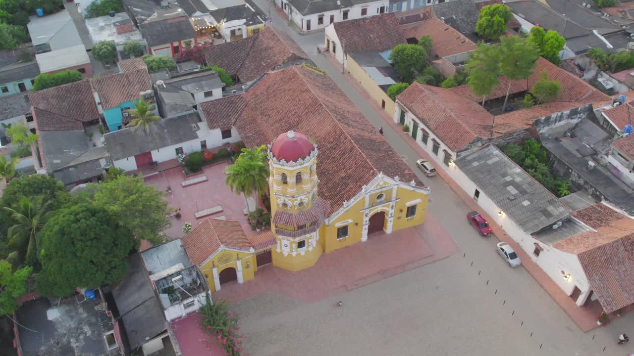 The iconic Santa Bárbara Church, a masterpiece of colonial-era design with its white walls and stunning baroque bell tower. Roll right with yaw left.