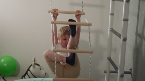 Emotional-toddler-boy-fails-to-go-up-rope-ladder-in-home-gym