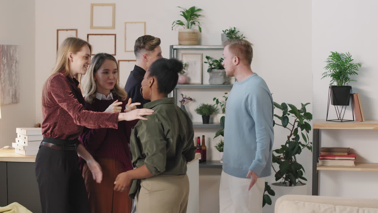 Happy Young People Greeting Each Other in Apartment