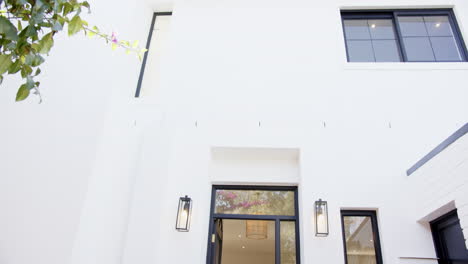 modern house exterior with large windows and open front door, inviting entrance