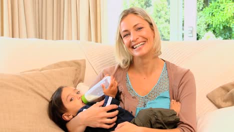 Mujer-Alimentando-Con-Biberón-A-Su-Hijo