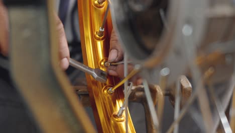 technician man working motorcycle wheel has spokes weave up on mechanic tool new steel wheel
