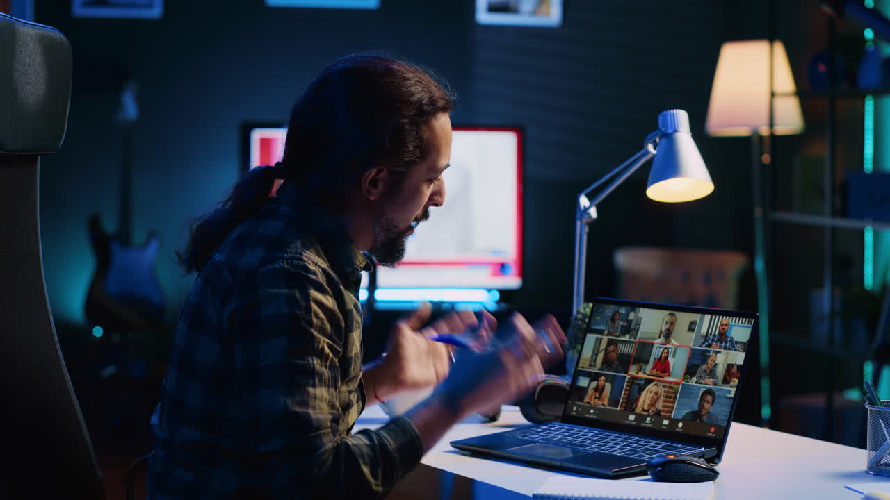 Remote worker greeting colleagues during videocall in apartment office