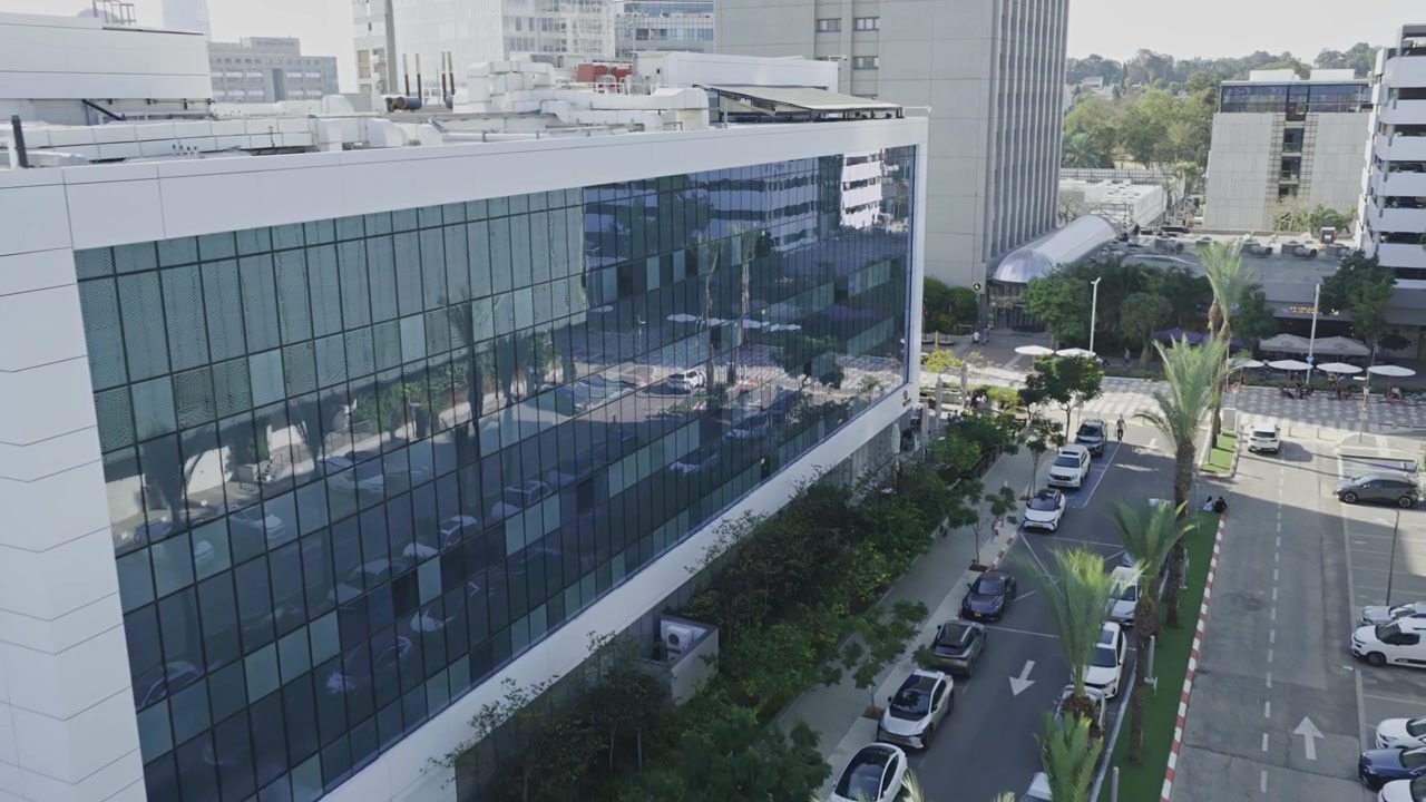 Vista aerea dall'alto con drone del quartiere degli affari Atidim Park a Tel Aviv, con torri per uffici high-tech con facciate in vetro e infrastrutture urbane.