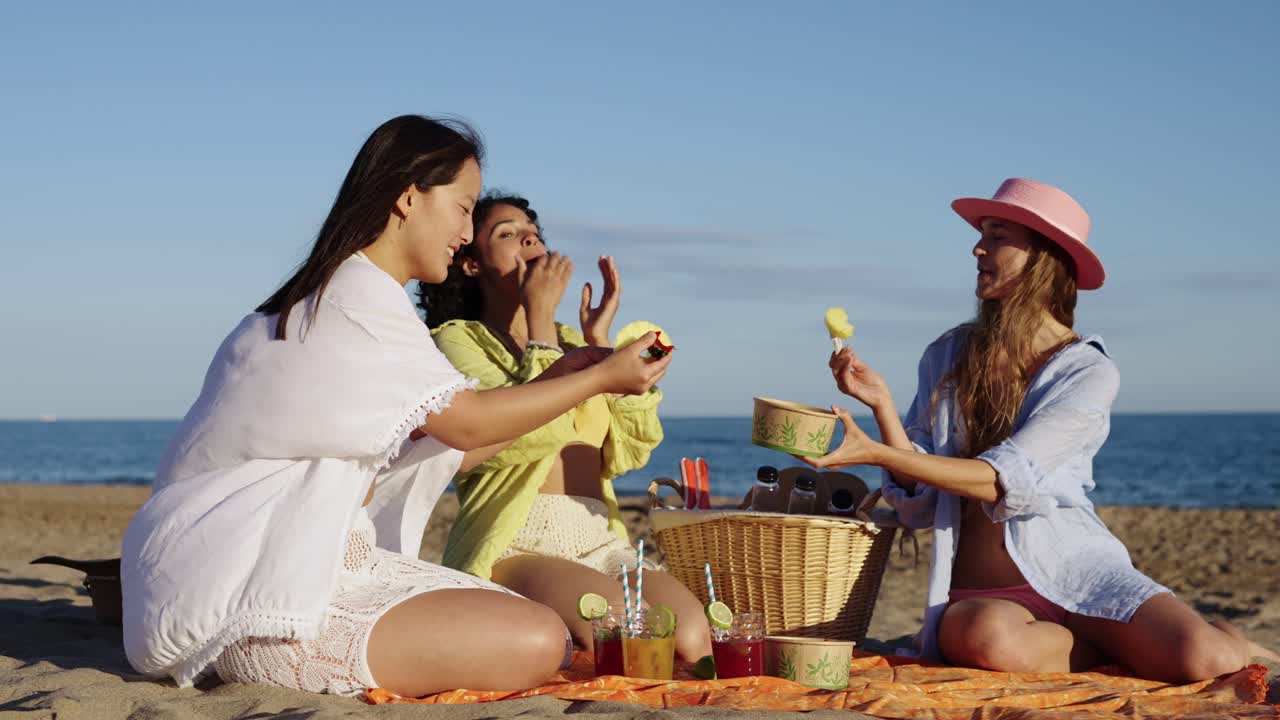 Friends enjoying a beach picnic on a sunny day