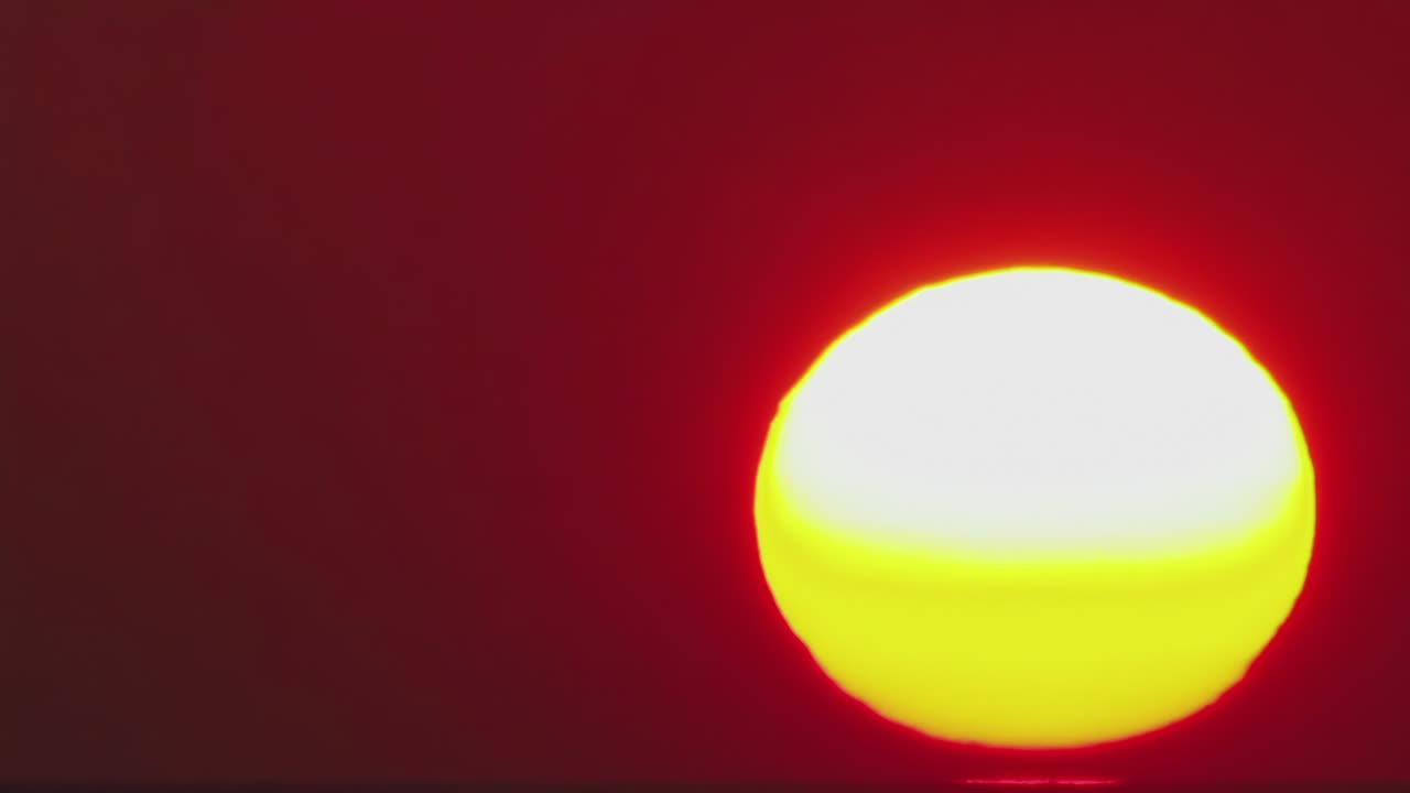 el lapso de tiempo, un gran sol se pone en nubes naranjas que se vuelven azules