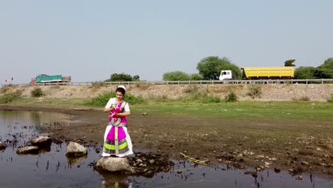 una bailarina de bharatnatyam que muestra una pose clásica de bharatnatyam en la naturaleza del lago vadatalav, pavagadh