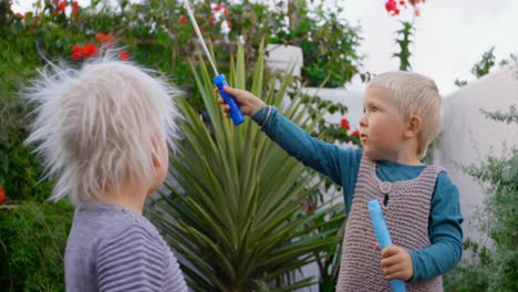 siblings playing with bubble wand in garden 4k