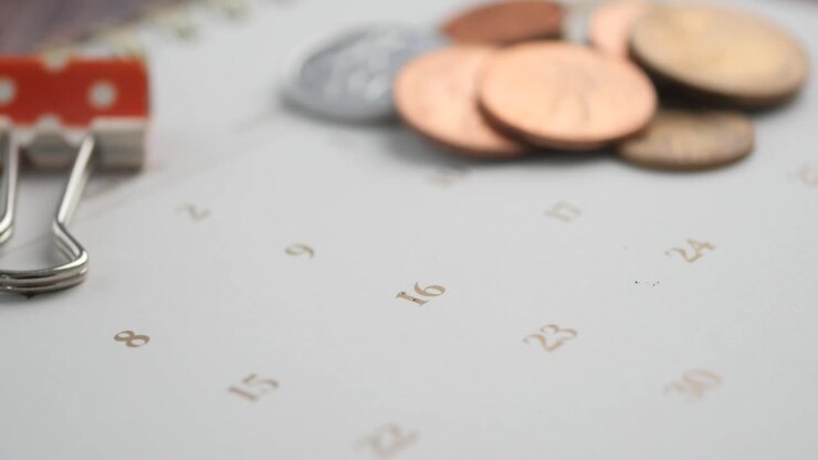 Promemoria calendario con puntina e monete