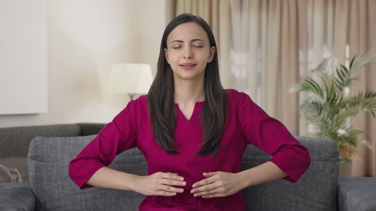Happy Indian woman doing breathe in breathe out exercise