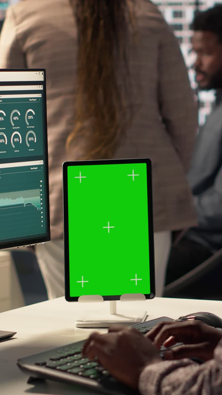 Person Typing on Keyboard with Green Screen Tablet in Modern Office