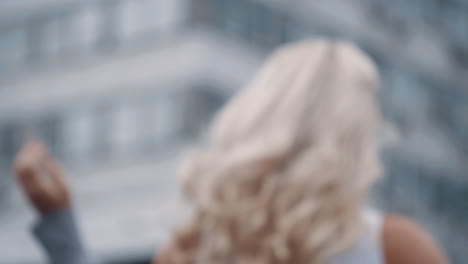 Female-model-posing-camera-in-city-walking-away-at-urban-background.