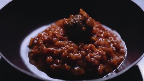sirviendo albóndigas en un plato con salsa de tomate rojo