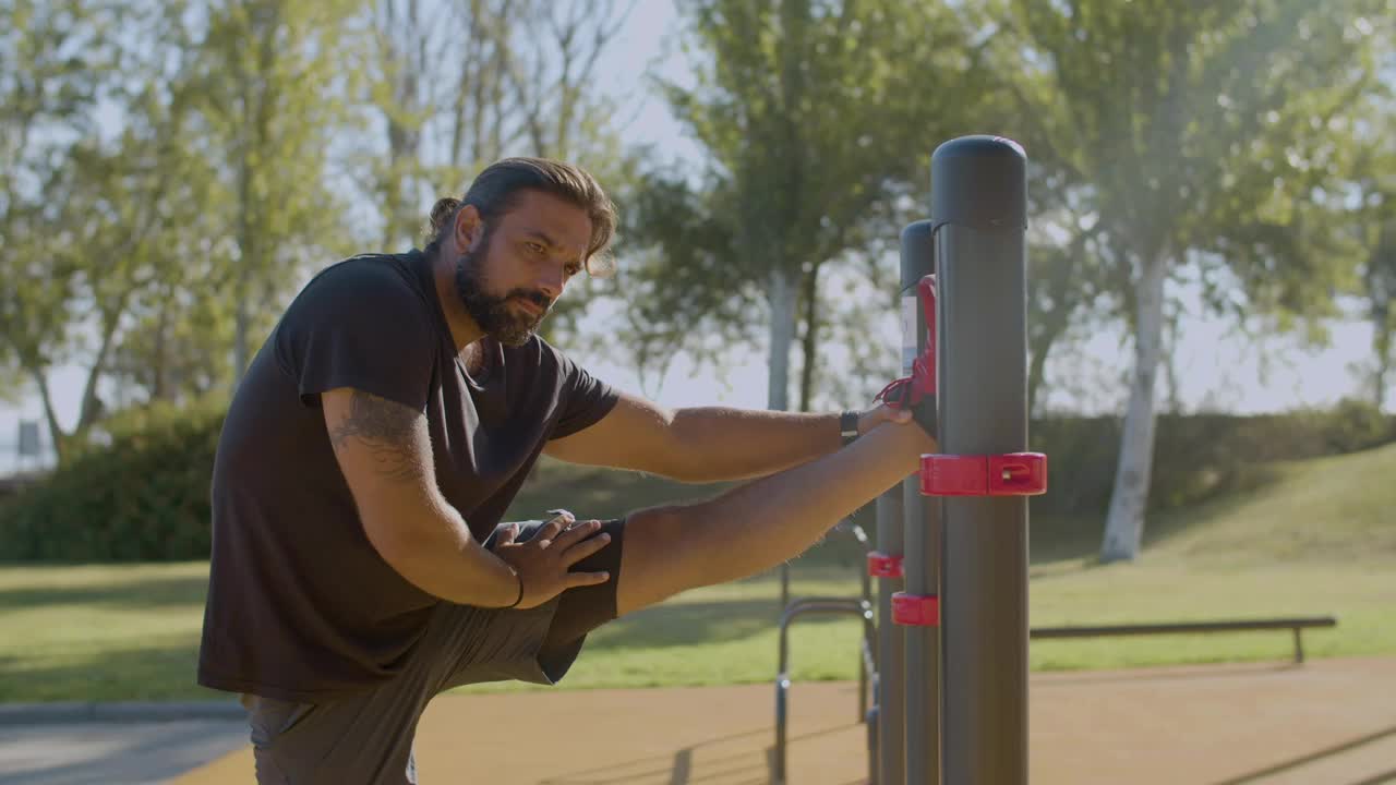 atleta masculino haciendo ejercicios de estiramiento en el parque por la mañana.