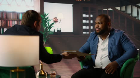 african american agent and his colleague analyzing evidence in a lounge
